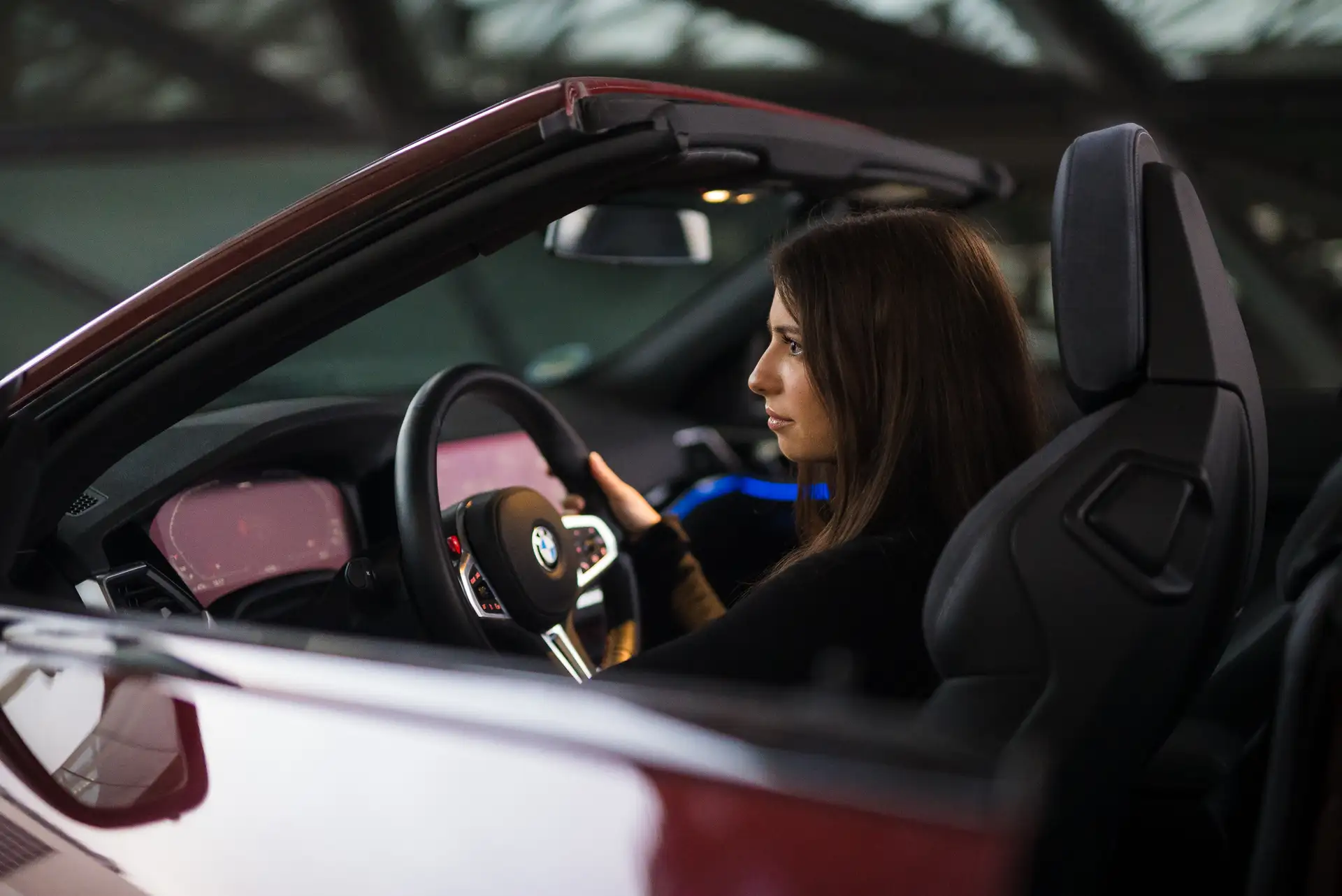 Frau fährt dunkelrotes BMW Cabrio von CarVia während einer Premium Miete mit Top Google Bewertungen