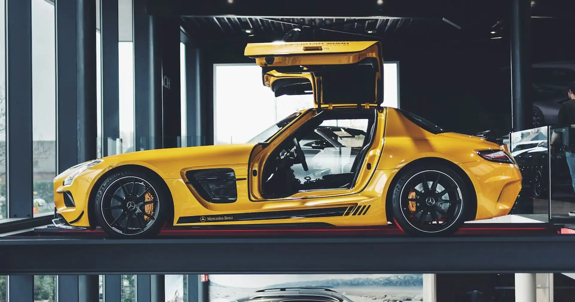 Mercedes SLS AMG in gelbgold seitlich mit Flügeltüren offen