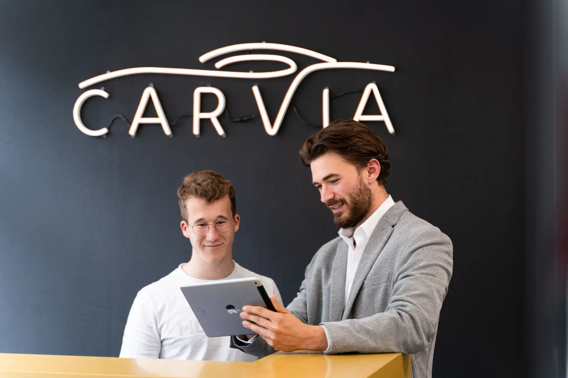 A CarVia employee shows another how to operate the iPad.