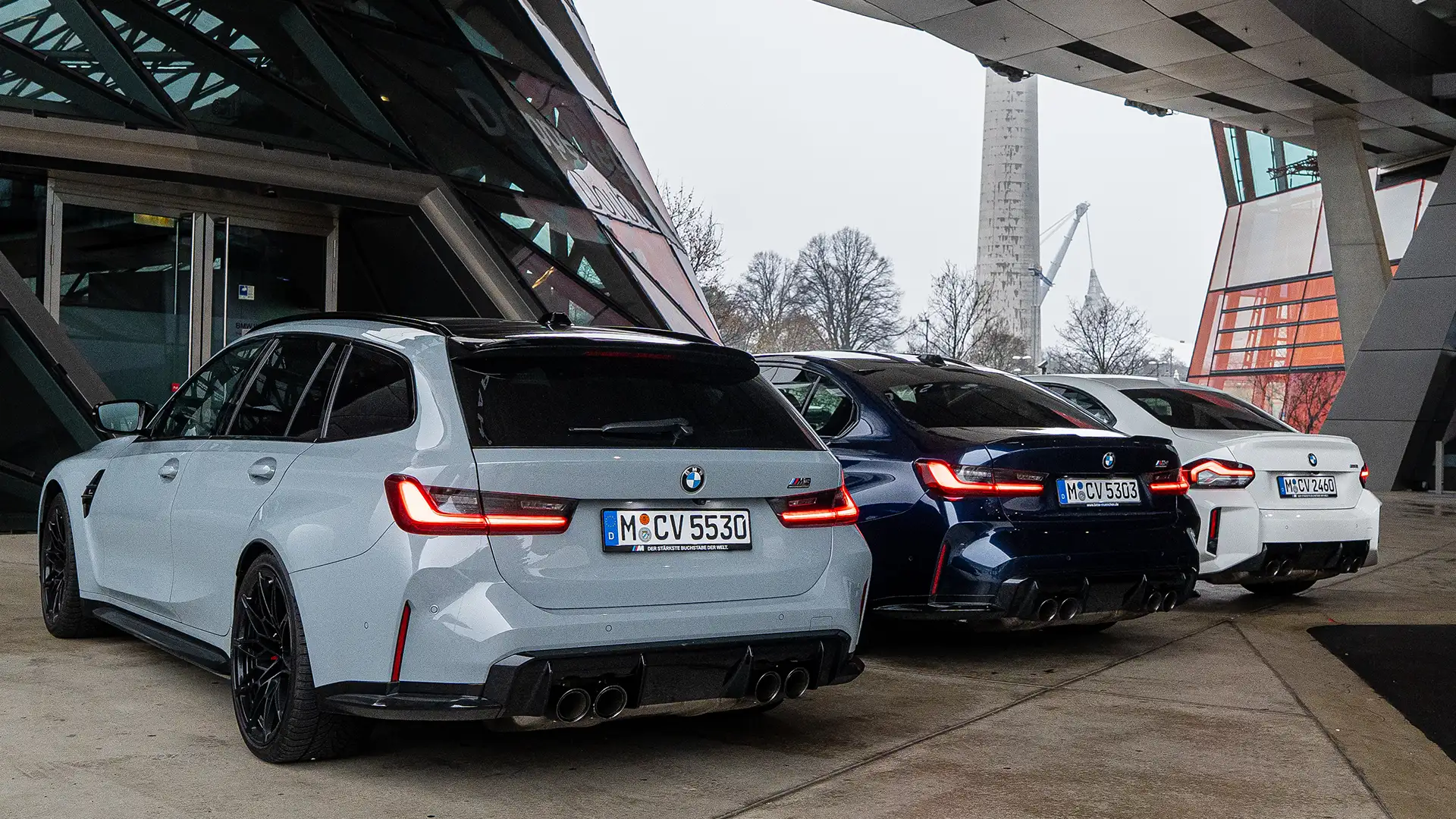 BMW M2, BMW M3 and BMW M3 Touring standing from behind in front of BMW Welt in Munich.