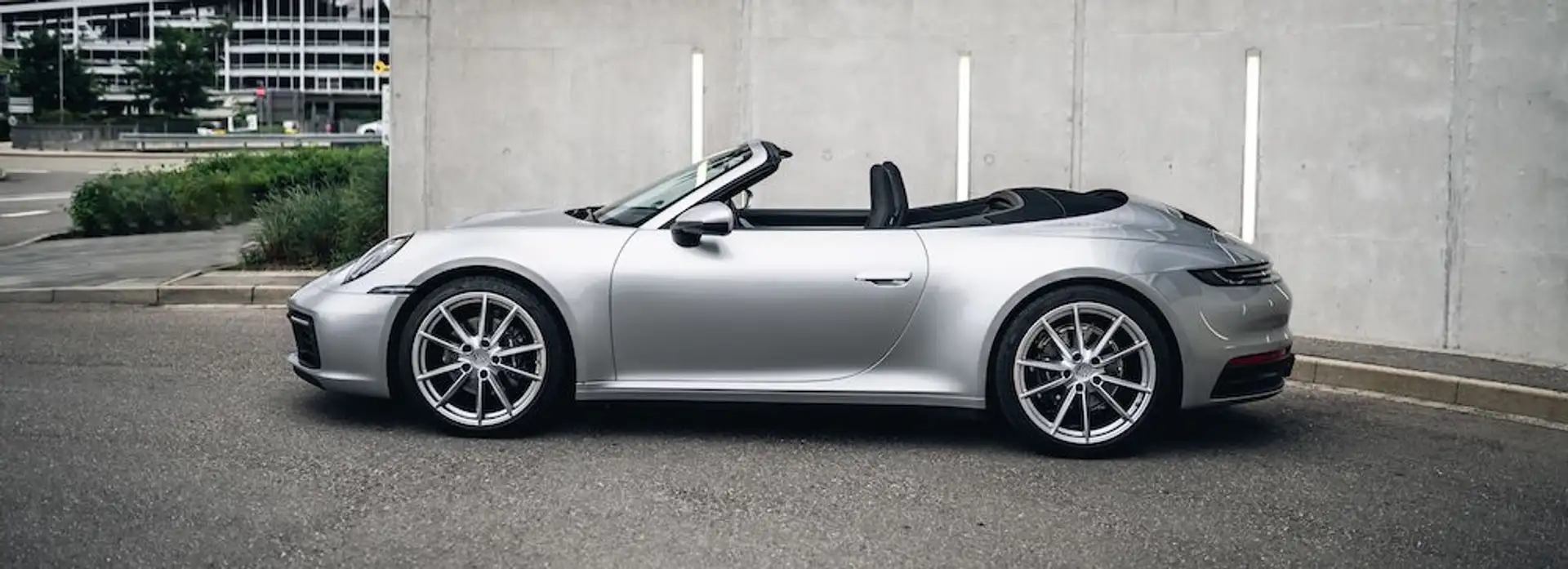 Porsche 911 Cabrio in silber mit offenem Verdeck von der Seite