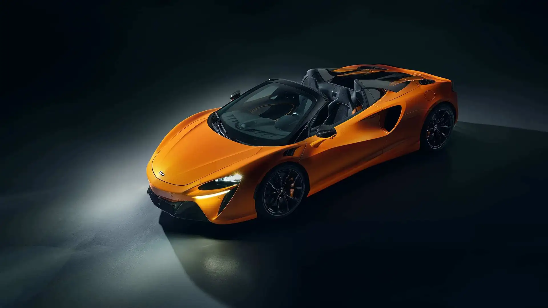 Mclaren Artura Spider in Orange Frontansicht mit Seite Schweinwerfer an im Fotostudio