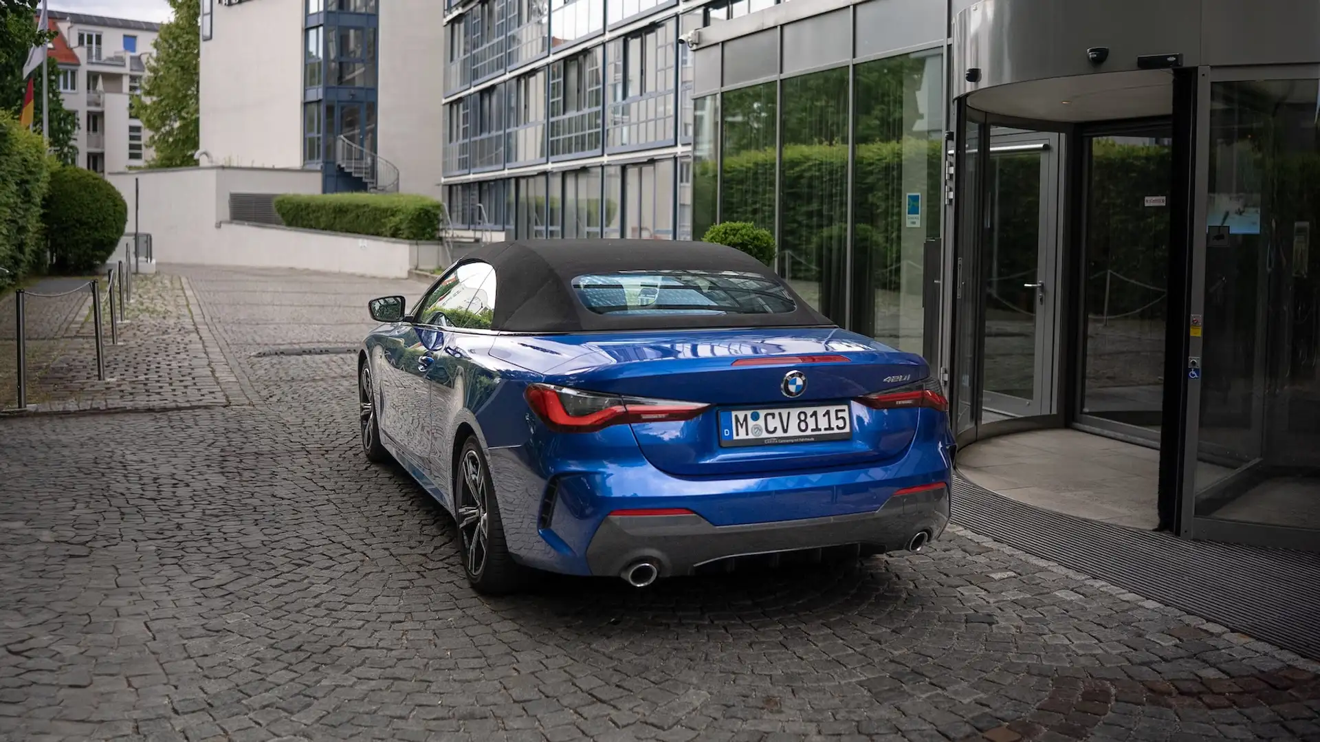 4 Series BMW convertible in blue in front of Hotel Pullman entrance from behind